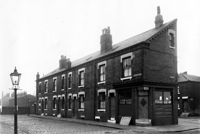 On the left of the image are numbers 2 to 8 Shand Grove, a row of back-to-back terraced houses with a shared outside toilet yard visible on the far left. On the right of the image and visible in the foreground is Jack Lane. At the corner with Shand Grove is number 6 Jack Lane, the Shand Fisheries. On the far right is New Princess Street. Pictured in April 1959.