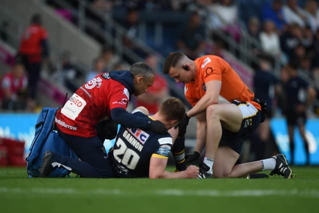 Rhinos' head of medical services Vas Mani (in red shirt), pictured tending to Morgan Gannon during the recent clash with St Helens. Picture by Matthew Merrick Photography/Leeds Rhinos.