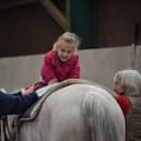 Paige enjoying a hippotherapy session - which involves physiotherapy on horseback.