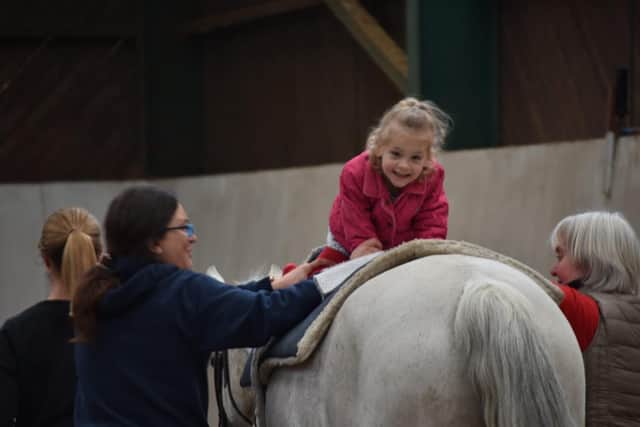 Paige enjoying a hippotherapy session - which involves physiotherapy on horseback.