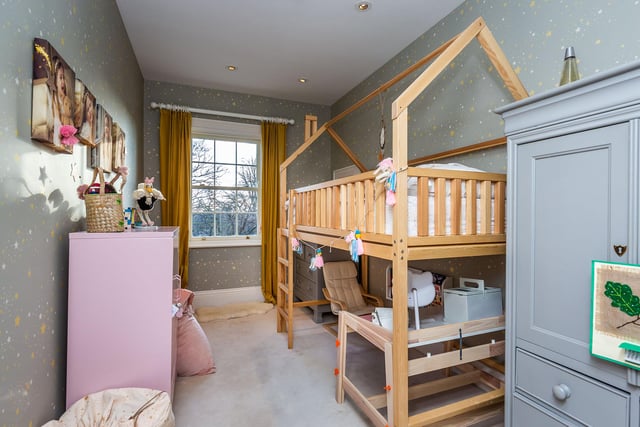 A child's bedroom boasts a four poster bed.