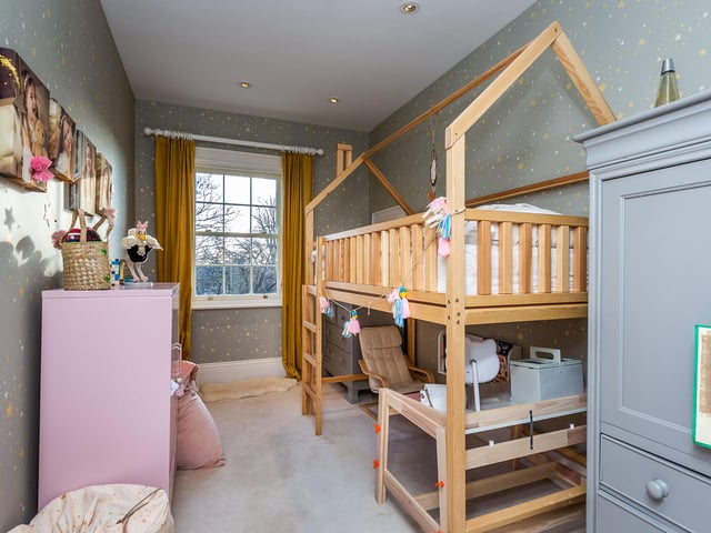 A child's bedroom boasts a four poster bed.