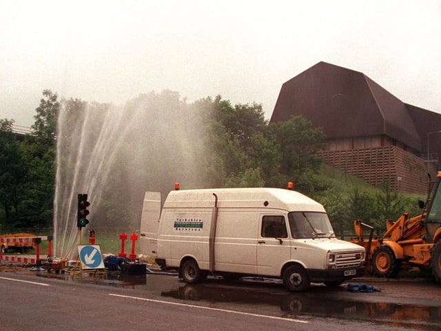 A burst pipe sends out jets of water on the Pontefract to Knottingley road in June 1997 as workmen wait for the mains to be turned off to begin repair work