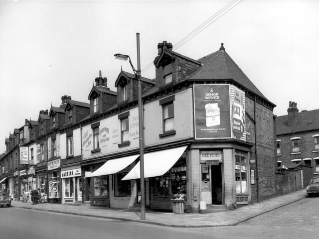 In the centre of the view from June 1965 is a branch of Martins the Cleaners. Moving right is C.W. Christopher & Son, plumbers and contractors. This firm was established in 1895 and displays a painted advertisement on the wall above. A shop with an awning follows, this is Tony Stevenson's Family Butchers. Towards the right, the shop at the corner of Tong Road and Barnet Road is number 134. This is a fruiterers run by H. Beever.