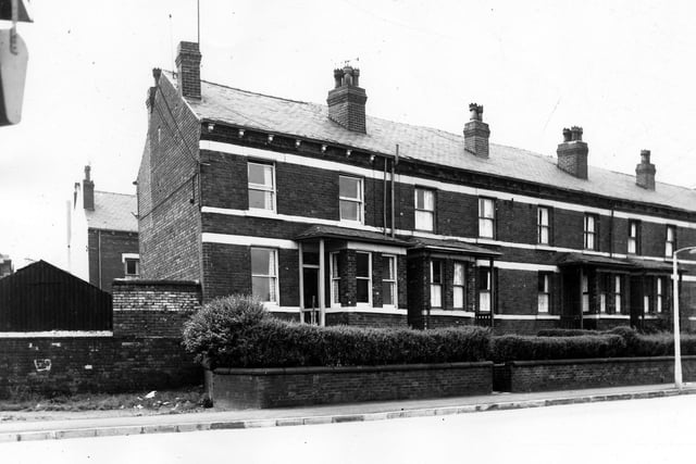 These back-to-back terraced houses on New Pepper Road each have a bay window, exposed porch and elevated entrance. Washing lines have been stretched across walled in gardens. On the far left is the side wall of the Orchard Mill, W.B. Johnson's rug factory. Pictured in August 1963.