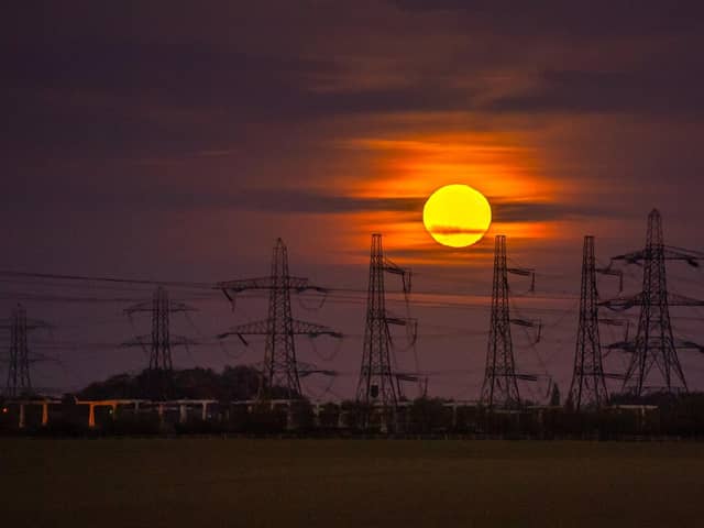 The Hunter's Moon rises above the electricity pylons at the National Grid Substation, west of Monk Fryston.