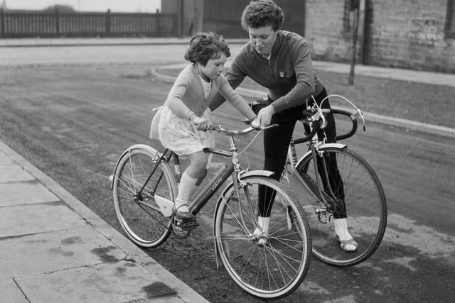 Beryl Burton, OBE was an English racing cyclist who dominated women's cycle racing in the UK, winning more than 90 domestic championships and seven world titles, and setting numerous national records. She set a women's record for the 12-hour time-trial which exceeded the men's record for two years. She is pictured with her daughter Denise in March 1963.