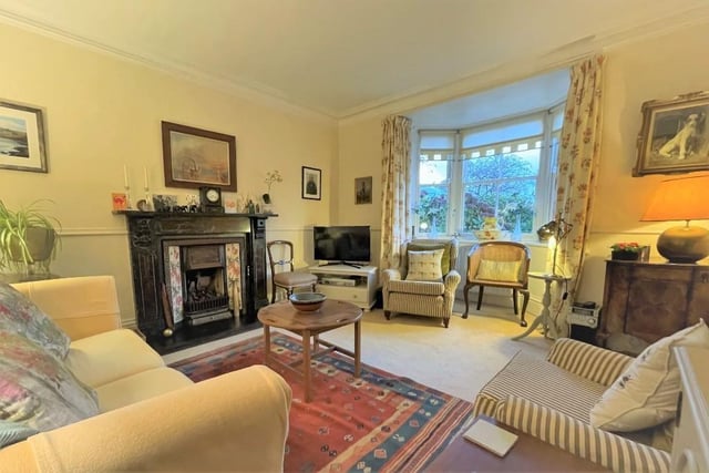 The sitting room, with a large front bay window, displays an original cast iron fireplace with tiled hearth.