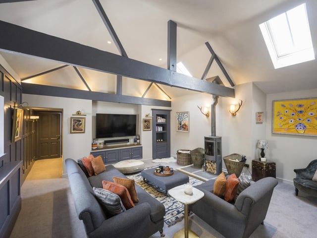 Open vaults to the ceiling and a log burner stove add a rustic warmth to this stylish sitting room.