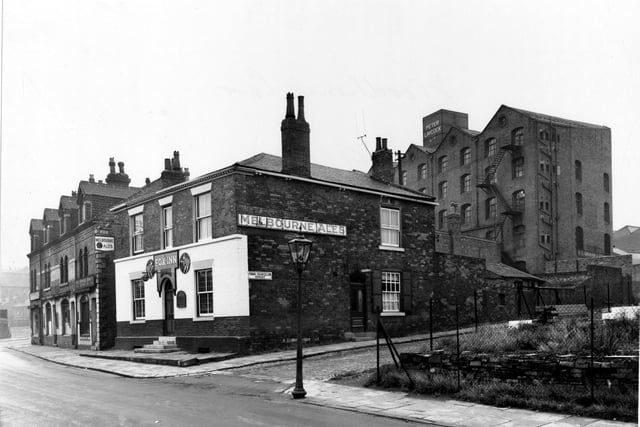 A view from area known as Woodhouse Carr, shows west side of street with the Fox Inn at the junction with Cross Chancellor Street.  In the background are the Perseverance Mills, used by Peter Laycock Ltd. Pictured in August 1956.