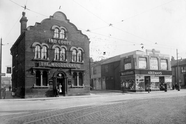 The Woodpecker pub at the junction of Burmantofts Street and York Road pictured in Septemebr 1935. The Woodpecker was no. 1 York Road, selling Ind Coope Beer, its landlord at the time was J. Hegarty. It was built in the early 19th Century and bought by Leeds Council in 1938 for £6,000. It closed in 1939 and a new Woodpecker Inn was built and opened on the opposite corner. On 15th March 1941 the old pub was severely damaged by bombing as was Maurice Adlemans' clothing store at nos. 3-5, seen here on the right advertising a summer sale; both were subsequently demolished. A new Adleman's store was built opposite next to the new Woodpecker.