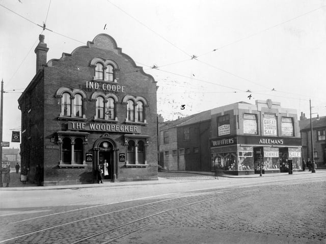 The Woodpecker pub at the junction of Burmantofts Street and York Road pictured in Septemebr 1935. The Woodpecker was no. 1 York Road, selling Ind Coope Beer, its landlord at the time was J. Hegarty. It was built in the early 19th Century and bought by Leeds Council in 1938 for £6,000. It closed in 1939 and a new Woodpecker Inn was built and opened on the opposite corner. On 15th March 1941 the old pub was severely damaged by bombing as was Maurice Adlemans' clothing store at nos. 3-5, seen here on the right advertising a summer sale; both were subsequently demolished. A new Adleman's store was built opposite next to the new Woodpecker.