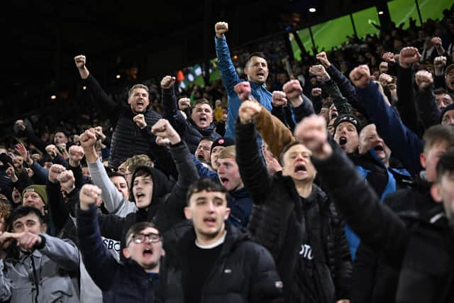 Leeds fans cheer and sing ahead of the English Premier League football match between Leeds United and Manchester City at Elland Road (Photo by OLI SCARFF/AFP via Getty Images)