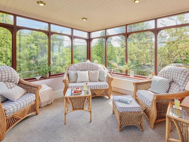 The conservatory is an airy space for the whole family to relax and enjoy the tree lined garden views.