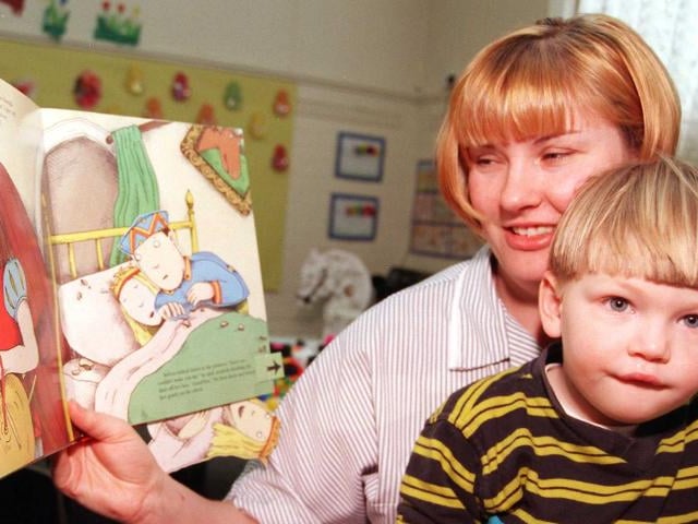 Tyler Burnip enjoying a story being told by his mother Elizabeth in 1999.