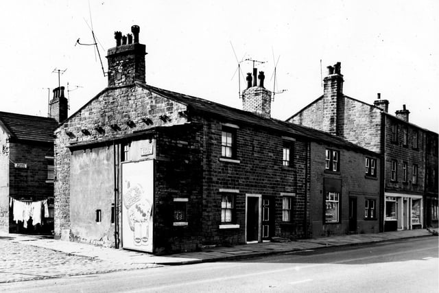 The junction of School Place on the left and Town Street on the right. On the far left the entrance to Mann's Square is visible where clothes hang on a line stretched across the street. At the corner is an advertisement for Batchelor's food products. On the right are numbers 11 to 17 Town Street, a row of back-to-back houses and through terraced shops. Pictured in September 1963.
