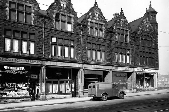 Numbers 111 to 117 on the west side of Chapeltown Road in September 1949. Shops shown are, 'D. Flockton, radio and electrical repairs', 'H.L. Horris, tailor', 'L. Margel, poultry dealer', 'Waldenberg and Gorwits, furnishers' and 'Leopold Stores'. A van is parked in front. Tramlines are visible.