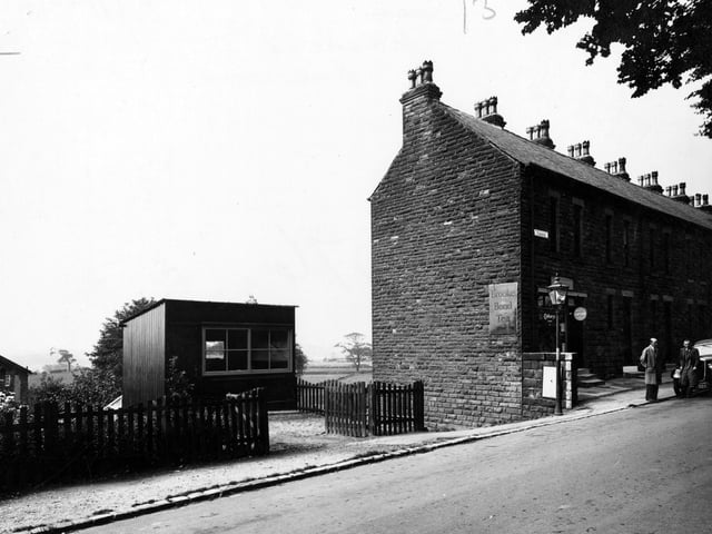 Two men stand by a parked car in front of a grocers shop on Parkside Road in July 1946. Advertisements for Brooke Bond Tea, Cadbury's and Capstan Cigarettes are visible.