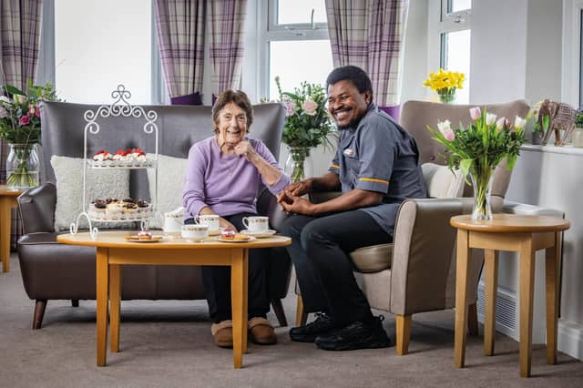 Colleague and resident at HC-One care home enjoying cup of coffee and slice of cake