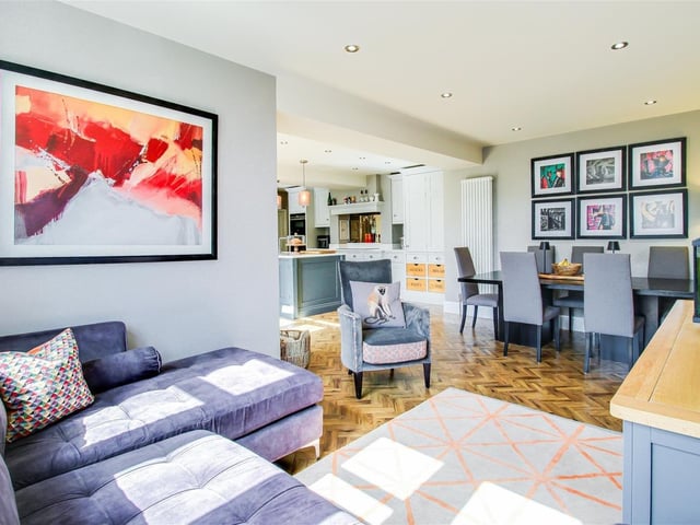 This room has an open plan layout leading into the kitchen breakfast area. There is two column style radiators, spotlights to the ceiling, and timber-framed double glazed windows to the front