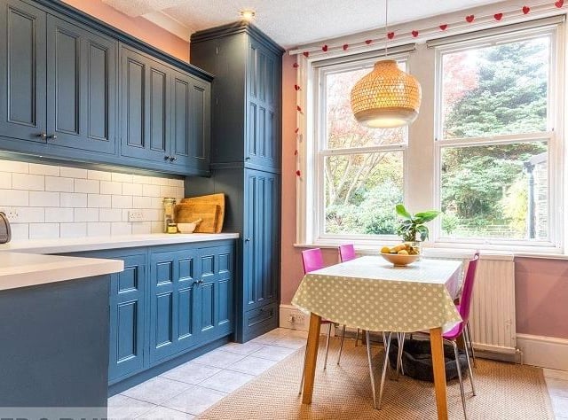 The breakfast kitchen, with fitted units, floods with natural light from the large windows.
