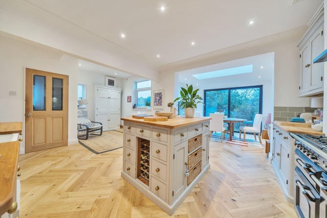 Furthermore, the rear of the property has been previously extended which has maximised the potential of the kitchen. It encompasses modern wall and base units with an island, contemporary kitchen wall tiling, handy sized utility room and further stunning flooring.