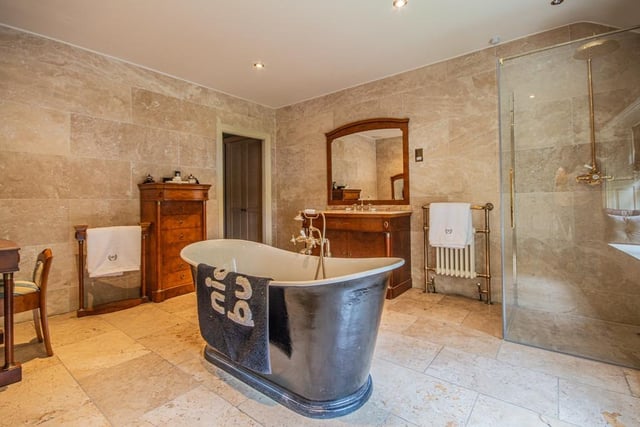 A free standing slipper bath and walk-in shower feature within this bathroom.