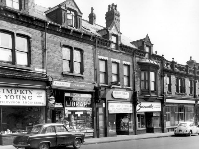 From left in June 1965, is Simpkin and Young, radio and television engineers. Then R & S.E. Bruce's confectioners and tobacconists. Jars of sweets line the shop windows. This shop was also a private lending library where members paid a small sum of money per week to borrow from a selection of books. Next, follows a chemists, business of Michael Teeman. Bosomworth's Furnishers was at number 180. At this time there was another Bosomworth's at number 198 Kirkstall Road. On the dormer windows of numbers 182 & 180 is the date 1893. On the right edge is part of the Leeds Industrial Co-operative Society Ltd, at number 178. This particular unit is vacant.