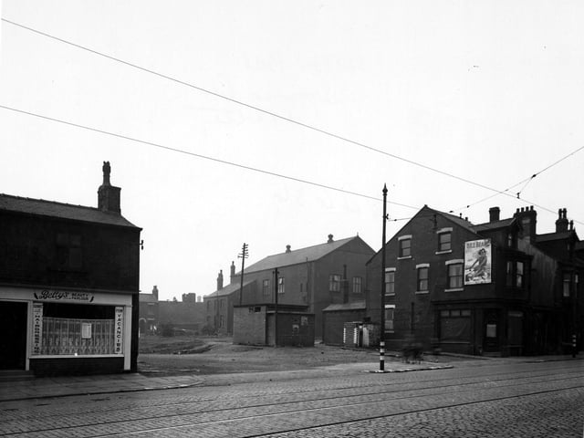 This photo shows an Air Raid Wardens Post on Driver Street viewed from Wellington Road, in the centre of the photograph. To the left is 'Bettys Beauty Parlour'. On the right is an empty shop with houses. On the side of the house is an advertisement for 'Bile Beans'. Tramlines and tram cables can be seen with blackout paint on the poles and also the kerbs. Pictured in September 1945.