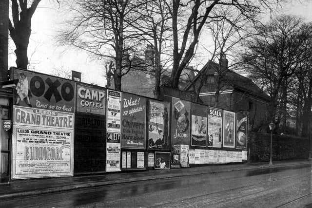 Advertising hoardings on Harrogate Road in February 1930 with posters for Oxo, Camp Coffee, Chivers Marmalade, Jacobs Crackers, Palethorpes sausage. On the left a poster advertises a performance of Gilbert and Sullivans Ruddigore, given by Leeds Amateur operatic and dramatic society at the Grand theatre, profits were for Leeds medical charities.