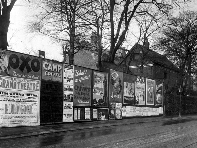Advertising hoardings on Harrogate Road in February 1930 with posters for Oxo, Camp Coffee, Chivers Marmalade, Jacobs Crackers, Palethorpes sausage. On the left a poster advertises a performance of Gilbert and Sullivans Ruddigore, given by Leeds Amateur operatic and dramatic society at the Grand theatre, profits were for Leeds medical charities.