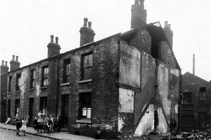 Children stood outside a derelict house on Thornton Street, the north side of Kirkstall Road, in July 1947. The house next door has been demolished.