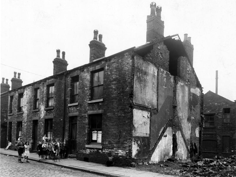 Children stood outside a derelict house on Thornton Street, the north side of Kirkstall Road, in July 1947. The house next door has been demolished.