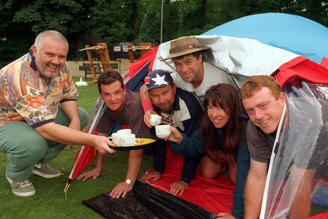 Pub landlord Martyn Goulding, left, brings out a morning cuppa for his Australian camping guests, from the left, Tony Roman, Darren Moulds, Bomber Dale, Catherine Bahr and Brad Wooding, as they emerge from their tent on the back lawn at The Original Oak pub, Headingley, Leeds.