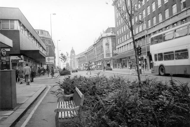 Looking west along The Headrow towards the Town Hall. On the left is the junction with King Charles Street, then Barkers TV and Musical Instruments at no. 91. Further along is the junction with Albion Street on both sides of the road. Visible on the right are the British Airways Travel Agents and Ceylon Tea Centre Restaurant.