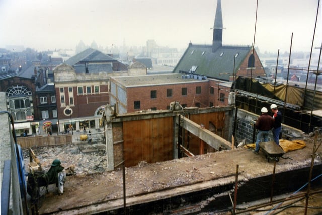 Demolition underway in readiness for construction of the Schofields Centre which opened in 1990. The view looks down onto the site and across to Lands Lane. The red brick and white building with the circular window housing shop premises in Lands Lane is located next to Angel Inn Yard and is called Scala House. It was formerly the premises of the 1,629 seater Scala Cinema which opened on 24th June 1922. Above the cinema there was the Scala Ballroom. Nearer to the camera is the rear of the red brick Church Institute at the corner of Lands Lane with Albion Place, addressed then as number 5 Albion Place.