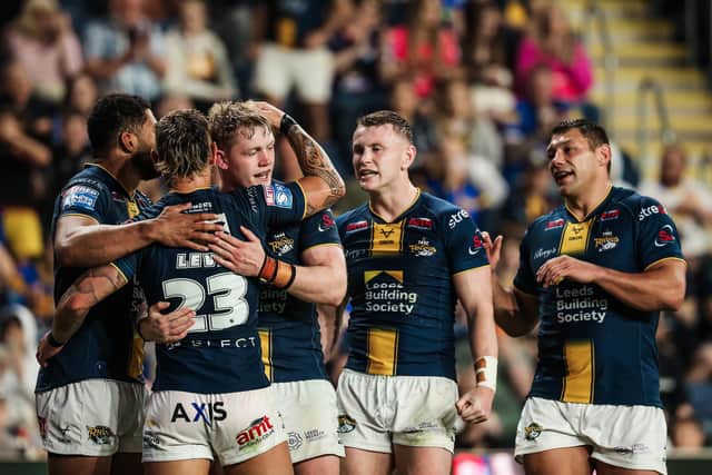 James McDonnell, third from left, is congratulated by teammates after scoring for Leeds Rhinos against Huddersfield Giants. Picture by Alex Whitehead/SWpix.com.