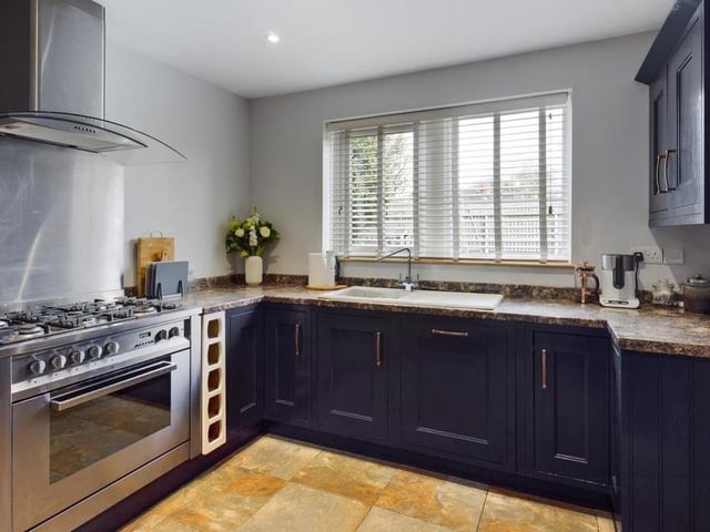 With fitted units and some integrated appliances, the kitchen has a breakfast bar, a pantry cupboard and a separate utility room.