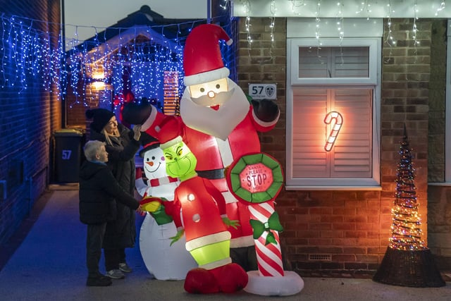Claire Tony and son James adjust a Santa outside one of the houses on the lane that has been transformed into a winter wonderland.
