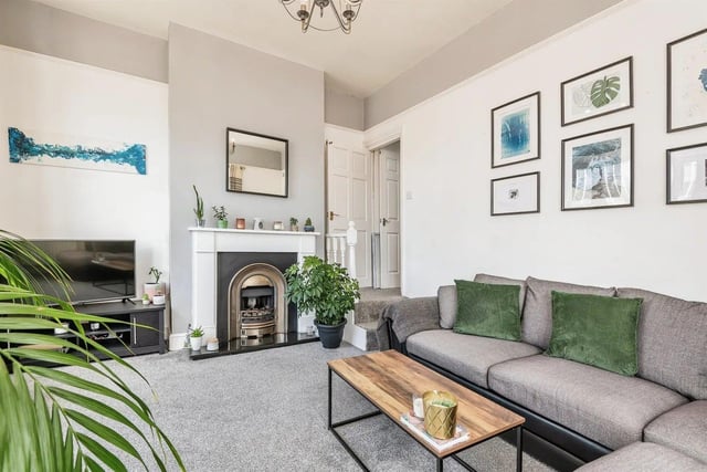 The light and airy living room has windows to the front and side of the property, with carpet, gas fire and central heating radiator.