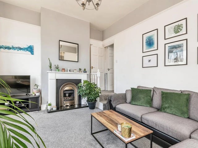 The light and airy living room has windows to the front and side of the property, with carpet, gas fire and central heating radiator.