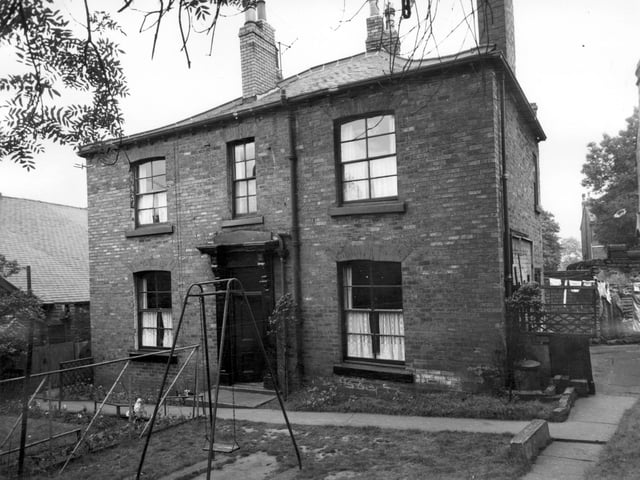 A family house on Beeston Road in July 1964. There is a swing in the garden. A barrier made from garden canes separates the play area from the planted area.