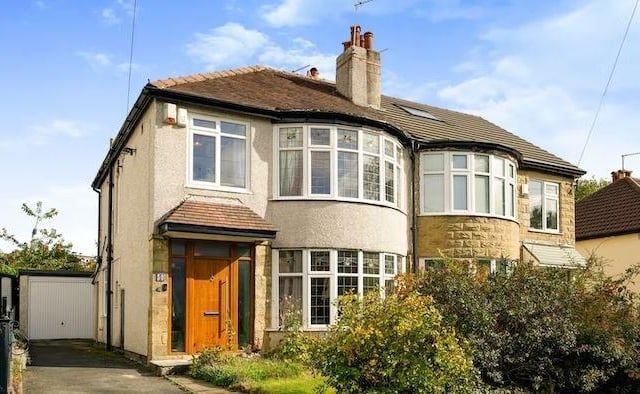 The property features a small front garden plus a driveway and garage for off-street parking.