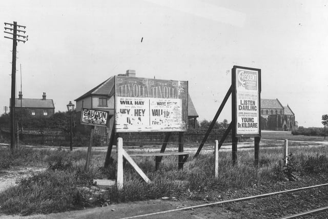 Looking north-east from Middleton Park Road across the tram line in July 1939. Some free-standing hoardings advertising the Tivoli and the Cresent Picture House lie beyond a small wire fence, partially obscuring two relatively new semi-detatched houses. To the right, situated on Middleton Park circus, is the recently relocated St Phillips Roman Catholic Church.