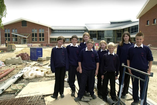 Brigshaw high School pupils, from left, Stephanie Hands, Lewis Todd, Emma James, Sean Bower, Megan Gladman, Daniel Hill, Katie Joynes and Alex Fletcher in front of the new school building, pictured on June 26, 2002.