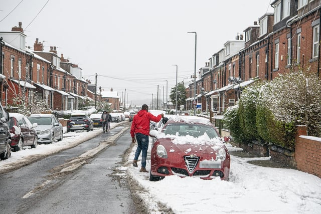 A commuter clears his car in Beeston, Leeds, after heavy snowfall overnight.