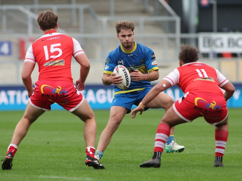 Oulton Raiders' Charlie Tetley finds his way blocked by East Leeds defenders Patrick O'Donovan and Isaac Coleman.
