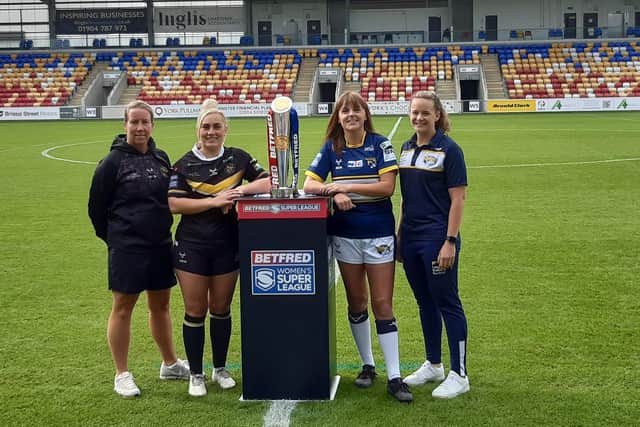 Rhinos captain Hanna Butcher and coach Lois Forsell with York Valkyrie rivals Lindsay Anfield and Sinead Peach - plus the Betfred Women's Super League trophy - at LNER Community Stadium. Picture by Peter Smith.