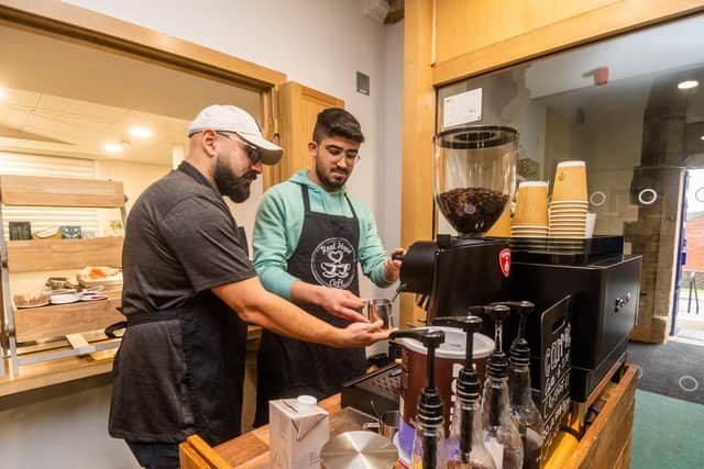 At Real Hope Cafe, Iranian coffee shop owner Arash Kourjani teaches the volunteers how to make coffee while they build their English skills. Photo: James Hardisty