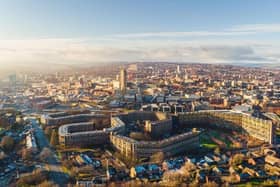 An aerial view of Sheffield looking over Park Hill flats and the city centre at sunrise.